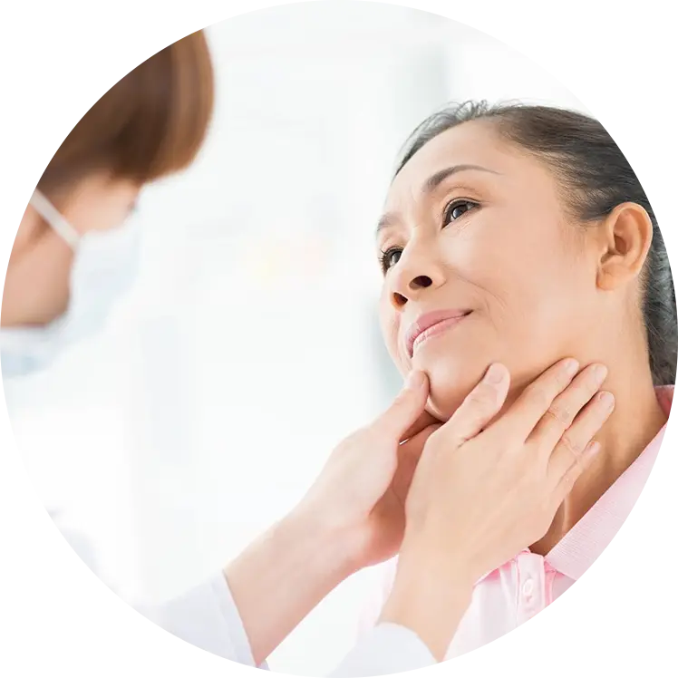 A woman is getting her thyroid checked by an asian doctor.