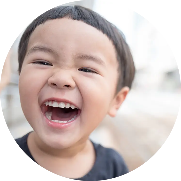 A young boy smiling with his mouth open.